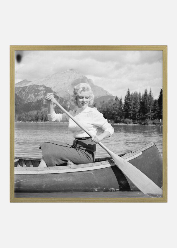 MARILYN MONROE IN A CANOE WITH HER EYES SLIGHTLY CLOSED
