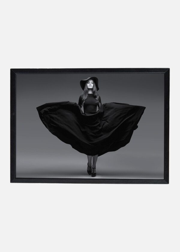 HIGH FASHION SHOT OF ELEGANT WOMAN IN A HAT AND LONG FLUTTERING DRESS