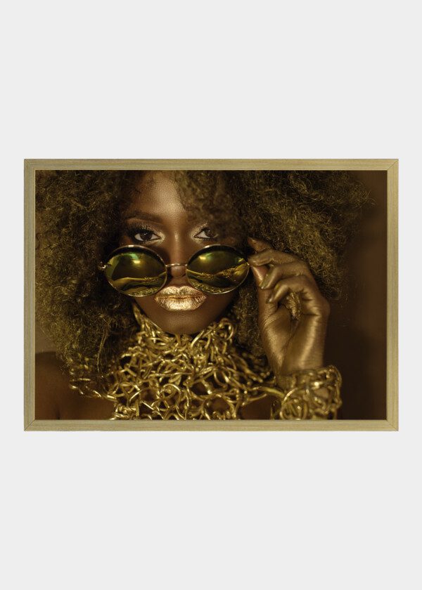 CLOSE-UP OF MAGIC GOLDEN AFRICAN AMERICAN FEMALE MODEL IN MASSIVE SUNGLASSES WITH BRIGHT GLITTER MAKEUP