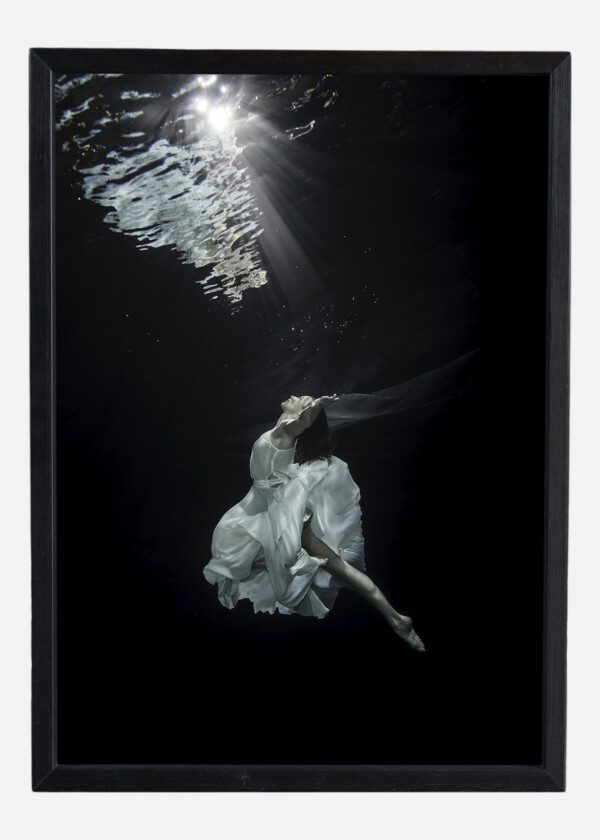 A YOUNG MALE BALLET DANCER IS DANCING UNDERWATER