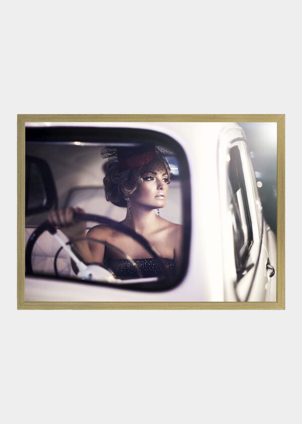 BEAUTIFUL SEXY FASHION BLOND GIRL MODEL WITH BRIGHT MAKEUP AND CURLY HAIRSTYLE IN RETRO STYLE SITTING IN OLD CAR