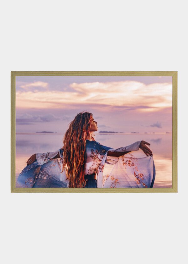 BEAUTIFUL YOUNG WOMAN IN ELEGANT DRESS ON THE BEACH AT SUNSET