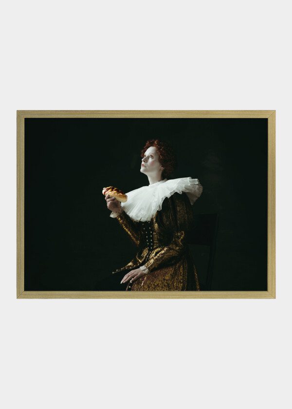 MEDIEVAL REDHEAD YOUNG WOMAN IN GOLDEN VINTAGE CLOTHING AS A DUCHESS EATING A HOT DOG