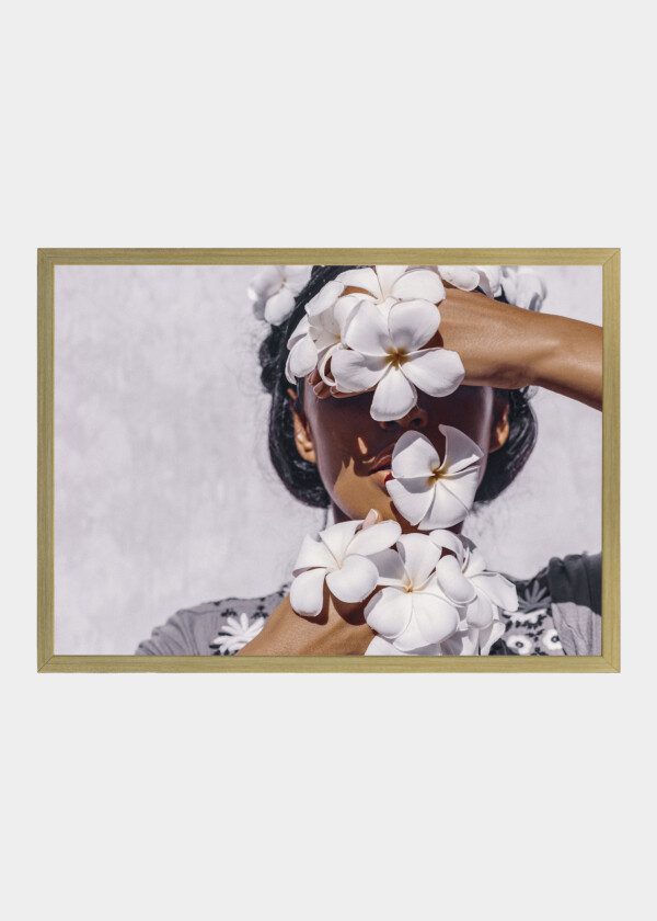 CLOSE UP OF BEAUTIFUL YOUNG WOMAN WEARING WREATH AND HOLDING FRANGIPANI FLOWERS